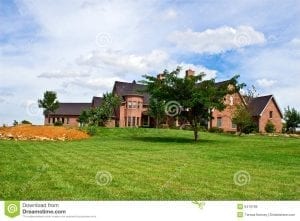 Luxury brick 2 story home surrounded by grass