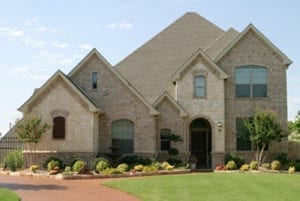 Brick 2 story house with landscaping, and paver driveway